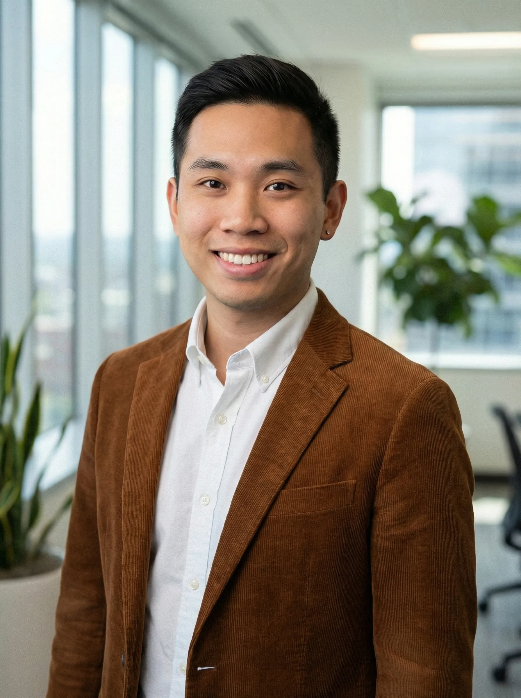 AI realtor headshot — man in a brown blazer and white shirt in a bright condo office